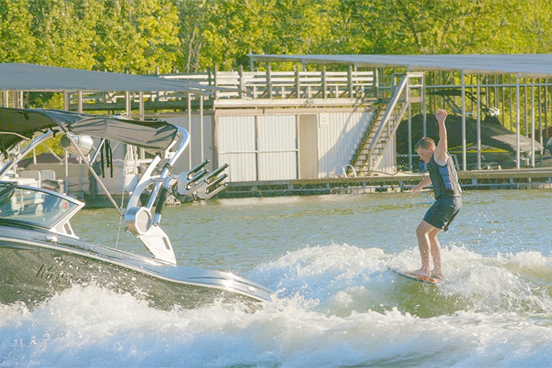 boy wakeboarding behind boat on lake | Mercer County, Kentucky